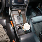 Wide installed view of the BMW E38 front cup holder with a drink and connected USB-C cable