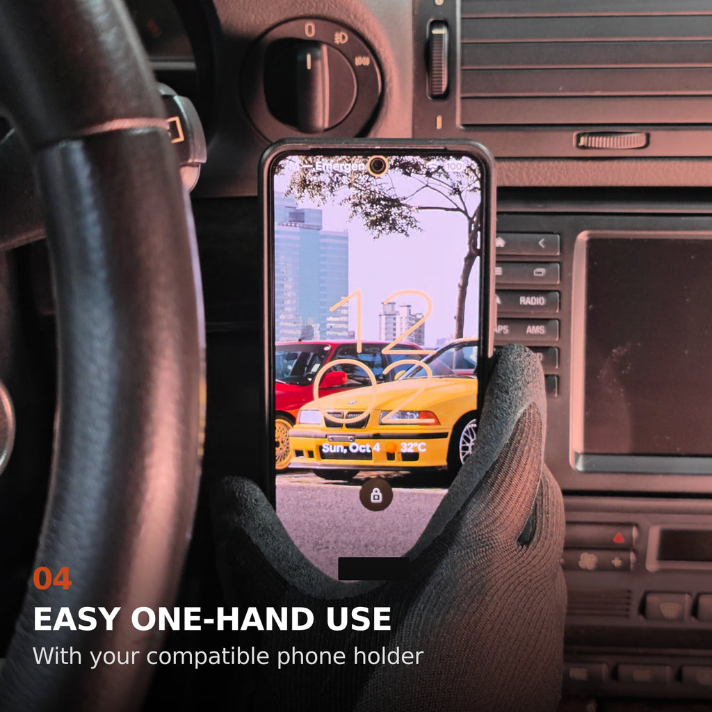 One gloved hand placing a phone onto a compatible holder on the BMW E38 dashboard mount. Personal lock-screen text is obscured.