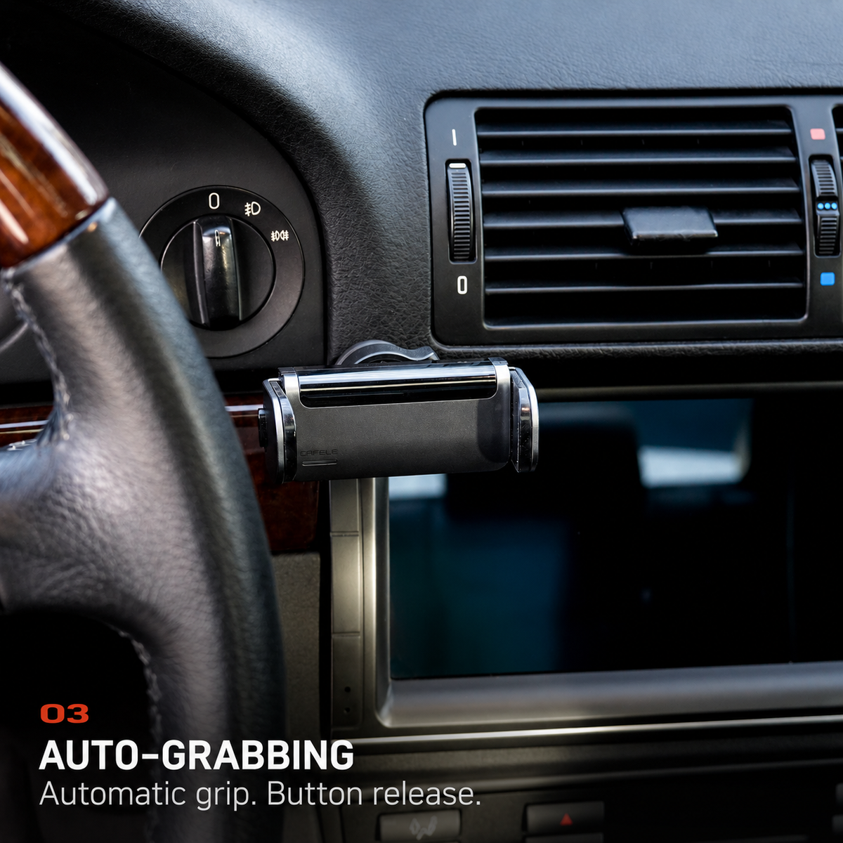 BMW E39 auto-grabbing phone holder installed beside the factory dashboard trim and center air vents.