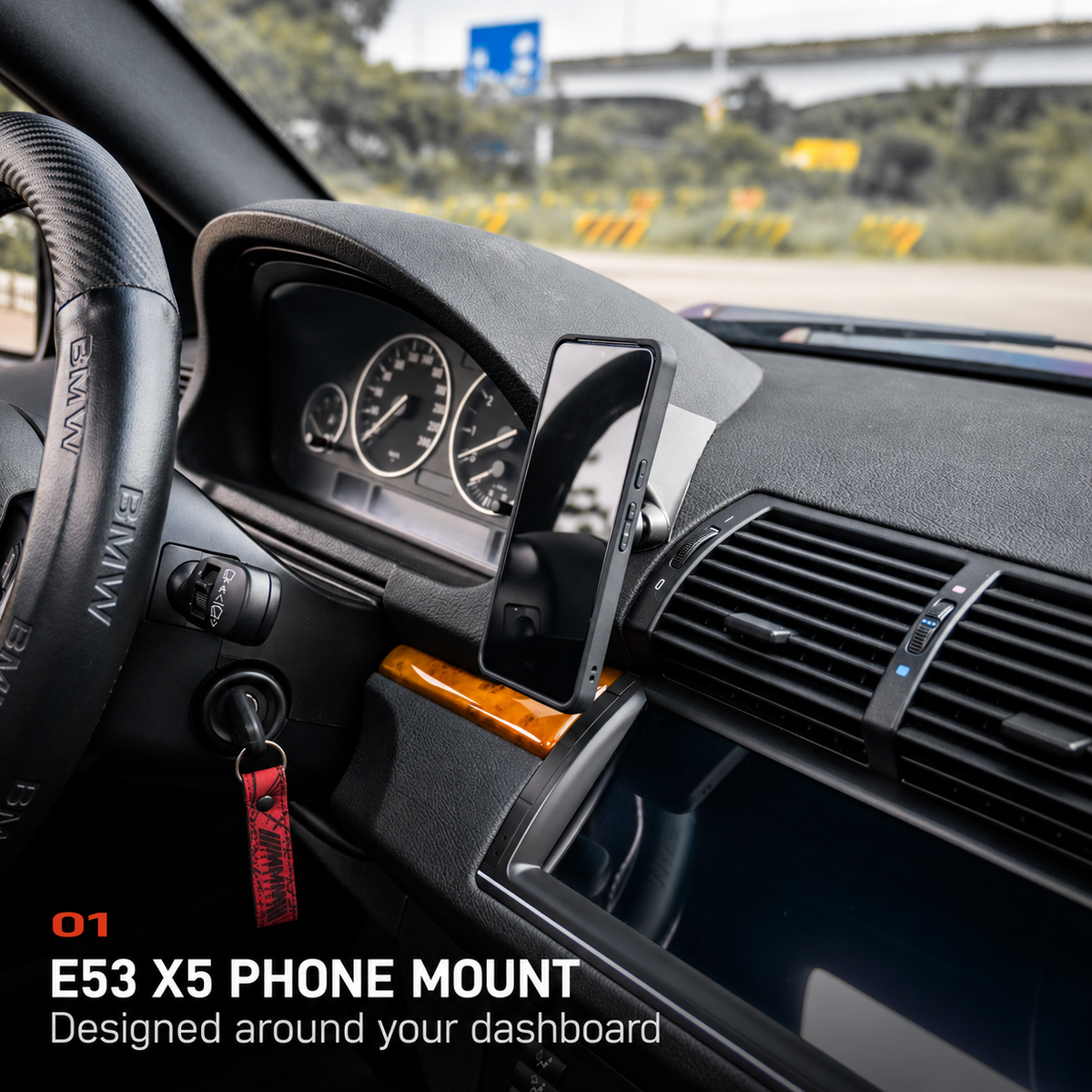 BMW E53 X5 phone mount with a phone installed beside the instrument cluster.